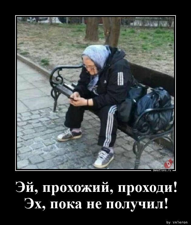 Эй, прохожий, проходи! Эх, пока не получил! Пожилая женщина в спортивном костюме сидит на скамейке и смотрит в телефон.