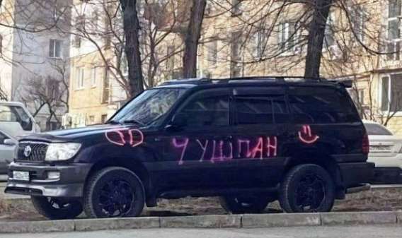 На черном внедорожнике, припаркованном на улице, розовой краской написано слово «ЧУШПАН» и нарисованы символы, похожие на букву D и смайлик.