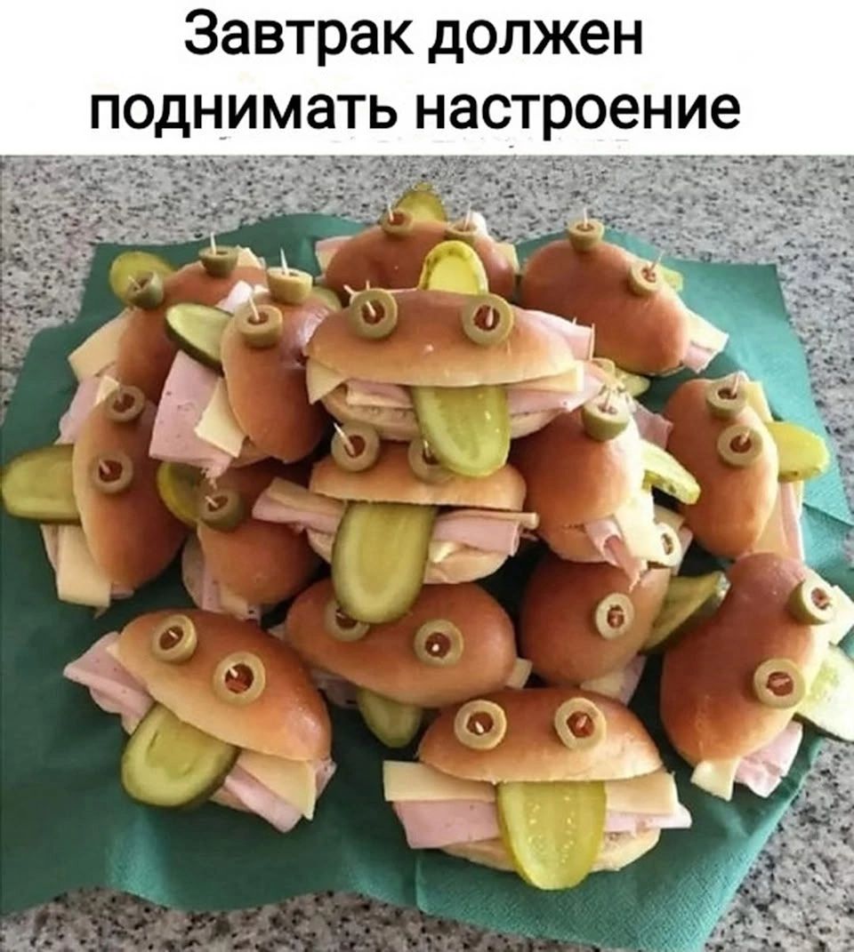 Завтрак должен поднимать настроение. На тарелке лежат маленькие бутерброды, оформленные в виде лягушек. Они сделаны из булочек, ветчины, сыра, маслин и огурцов. Огурцы торчат как языки, а маслины служат глазами.