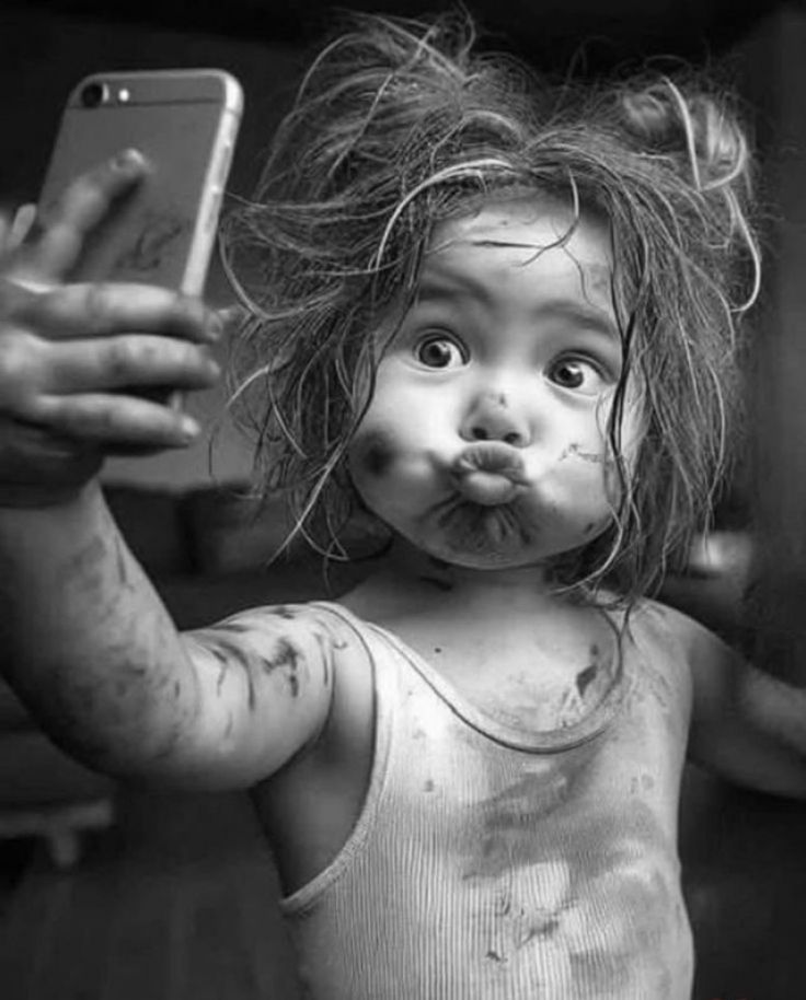 Маленький ребенок делает селфи с грязью на лице