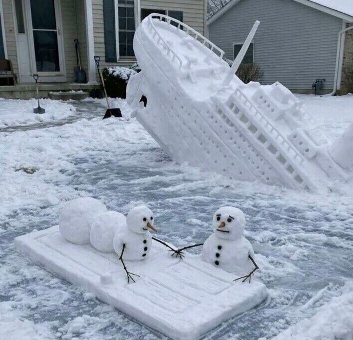 Снежные скульптуры: два снеговика и перевернувшийся снежный корабль во дворе.