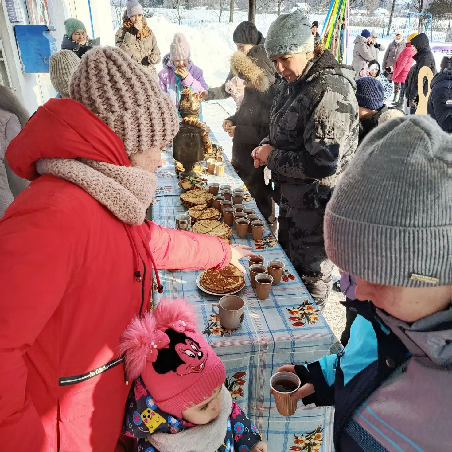 Зимняя ярмарка: люди выбирают выпечку за столами