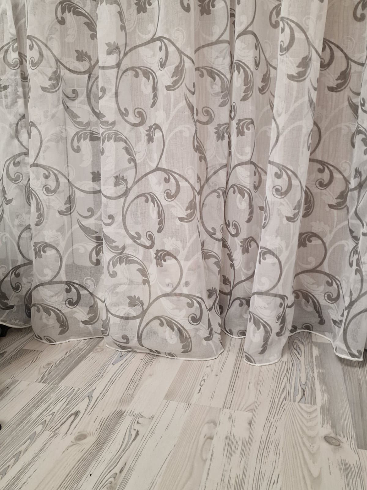 Шторы с узорным рисунком в комнате на светлом полe