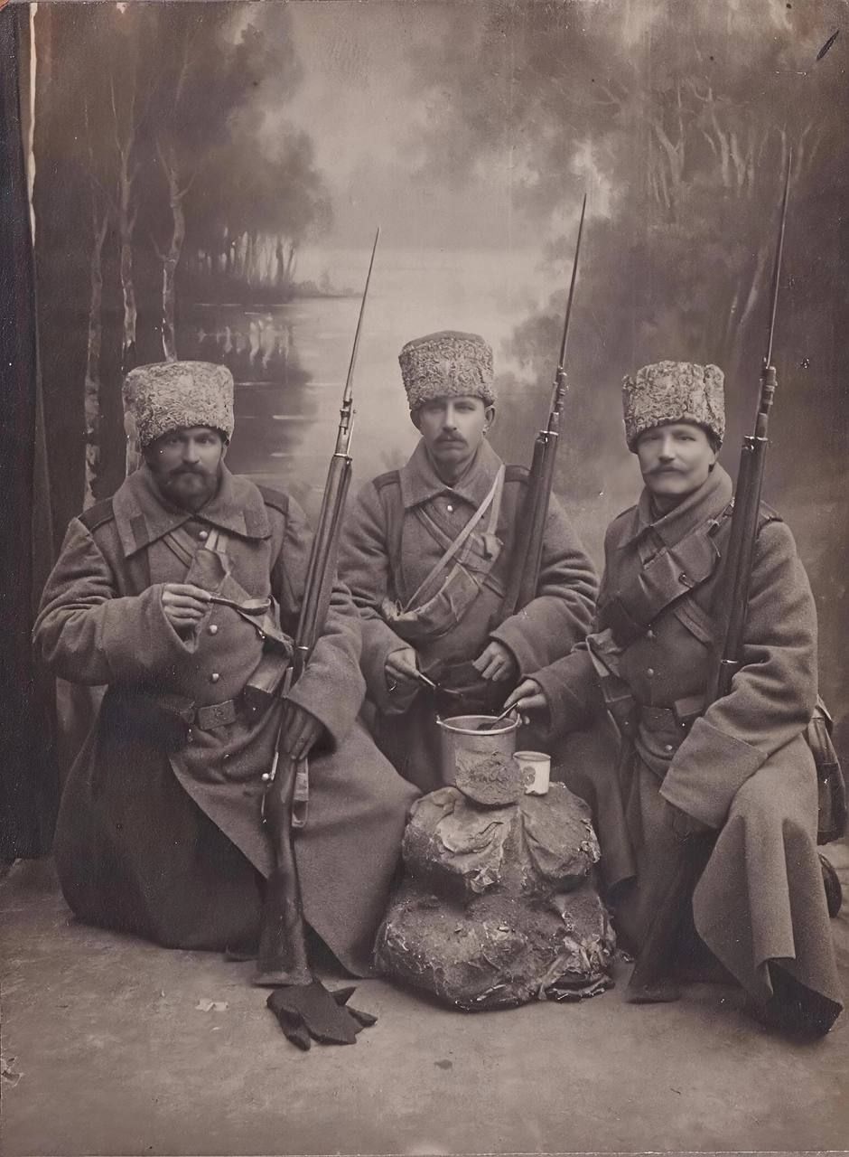 Три солдата в старой форме с ружьями на студийной фотосессии.