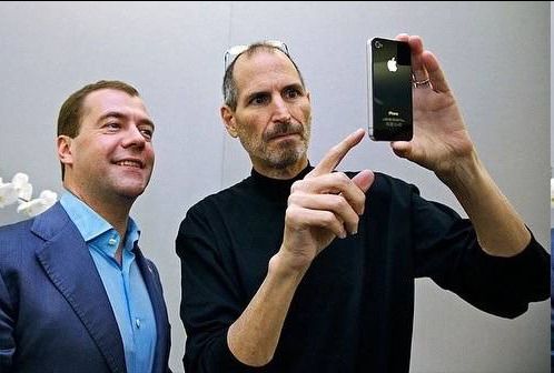 Двое мужчин делают селфи в зеркале.