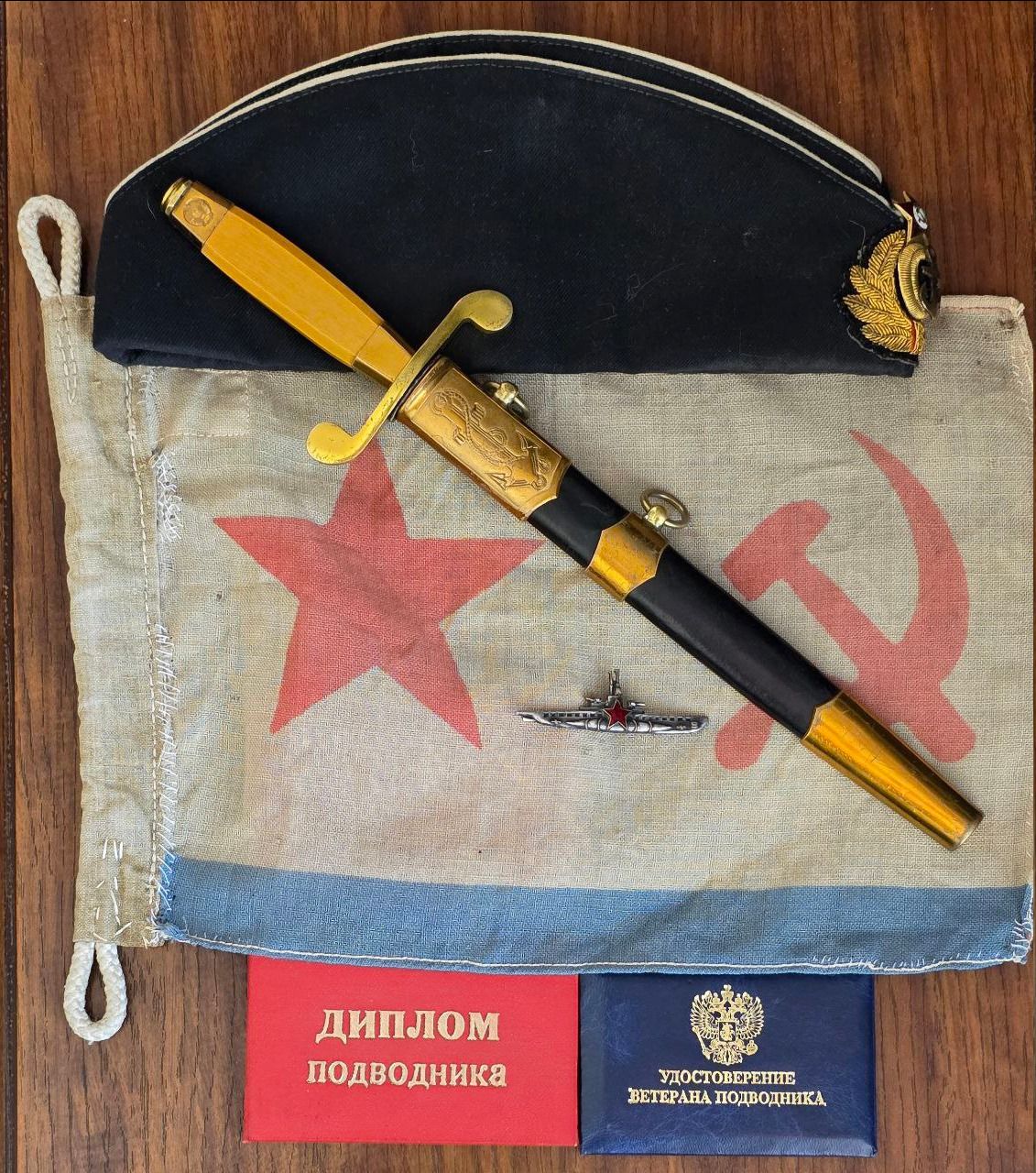 ДИПЛОМ ПОДВОДНИКА, УДОСТОВЕРЕНИЕ ВЕТЕРАНА ПОДВОДНИКА. Предметы, связанные с советским военно-морским флотом и подводниками: кортик, фуражка, флаг с символикой СССР, значок подводной лодки.
