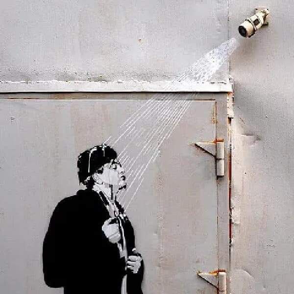 Уличное граффити: человек под струёй воды из водопроводного крана.