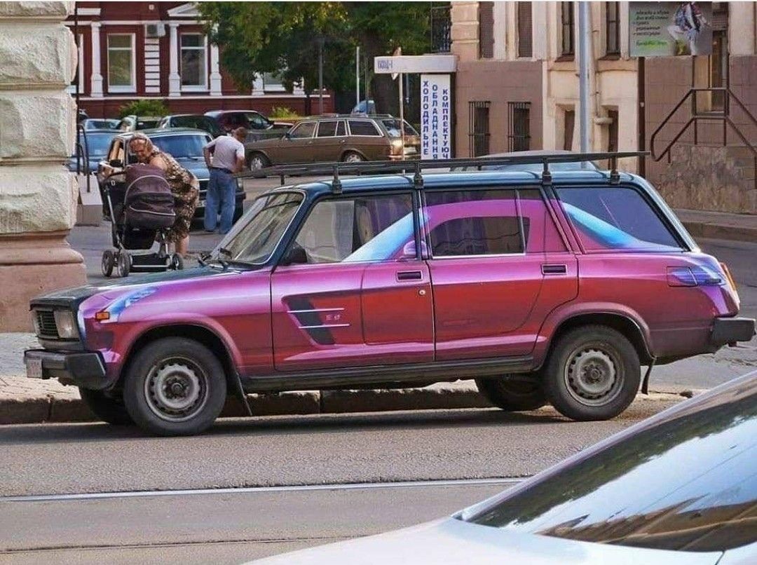 Ярко-розовый старый внедорожник на улице перед зданием