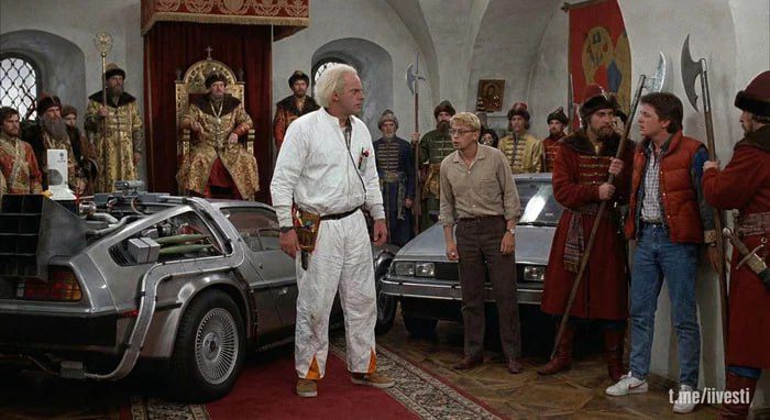 Комедийная сцена в зале с персонажами и автомобилем посередине.