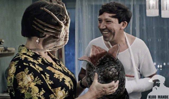 Улыбающиеся люди держат курицу в руках, в помещении.