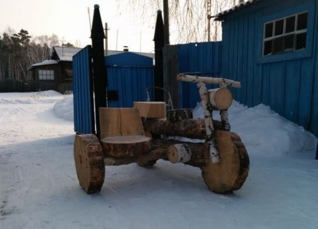 Деревянный самодельный вездеход на снежной улице рядом с голубой будкой.
