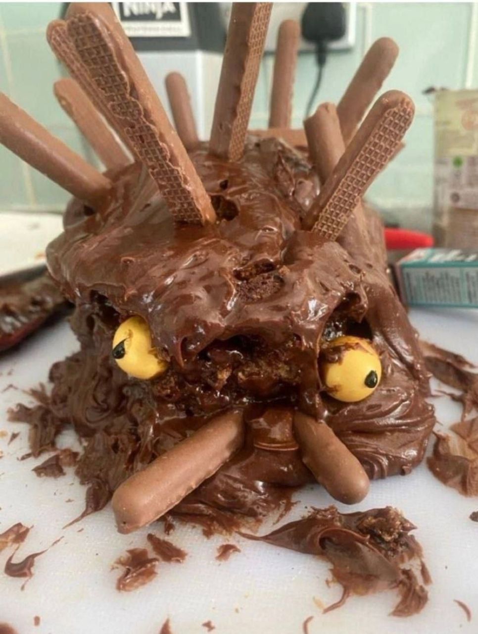 Шоколадный монстр из торта с палочками и глазами.