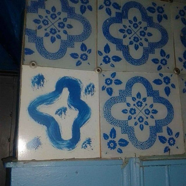 Плитки с голубым узором; одна плитка с абстрактной формой.