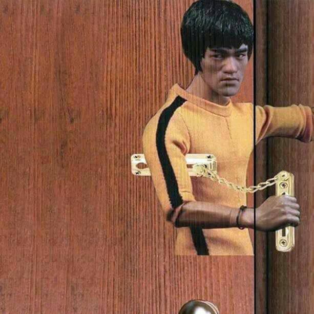 Человек в жёлтой футболке за дверью, связанный цепью.