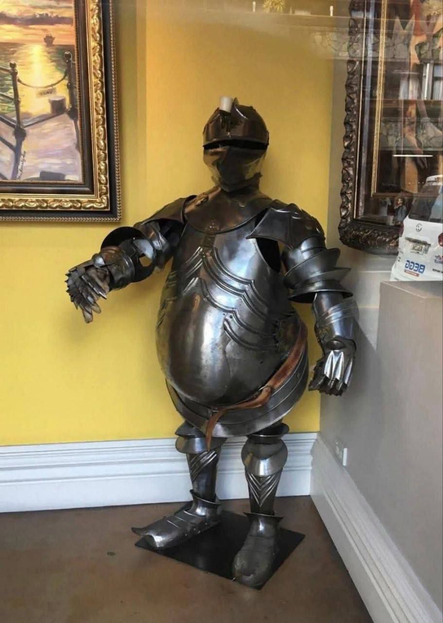 Рыцарский доспех в помещении рядом с картинами