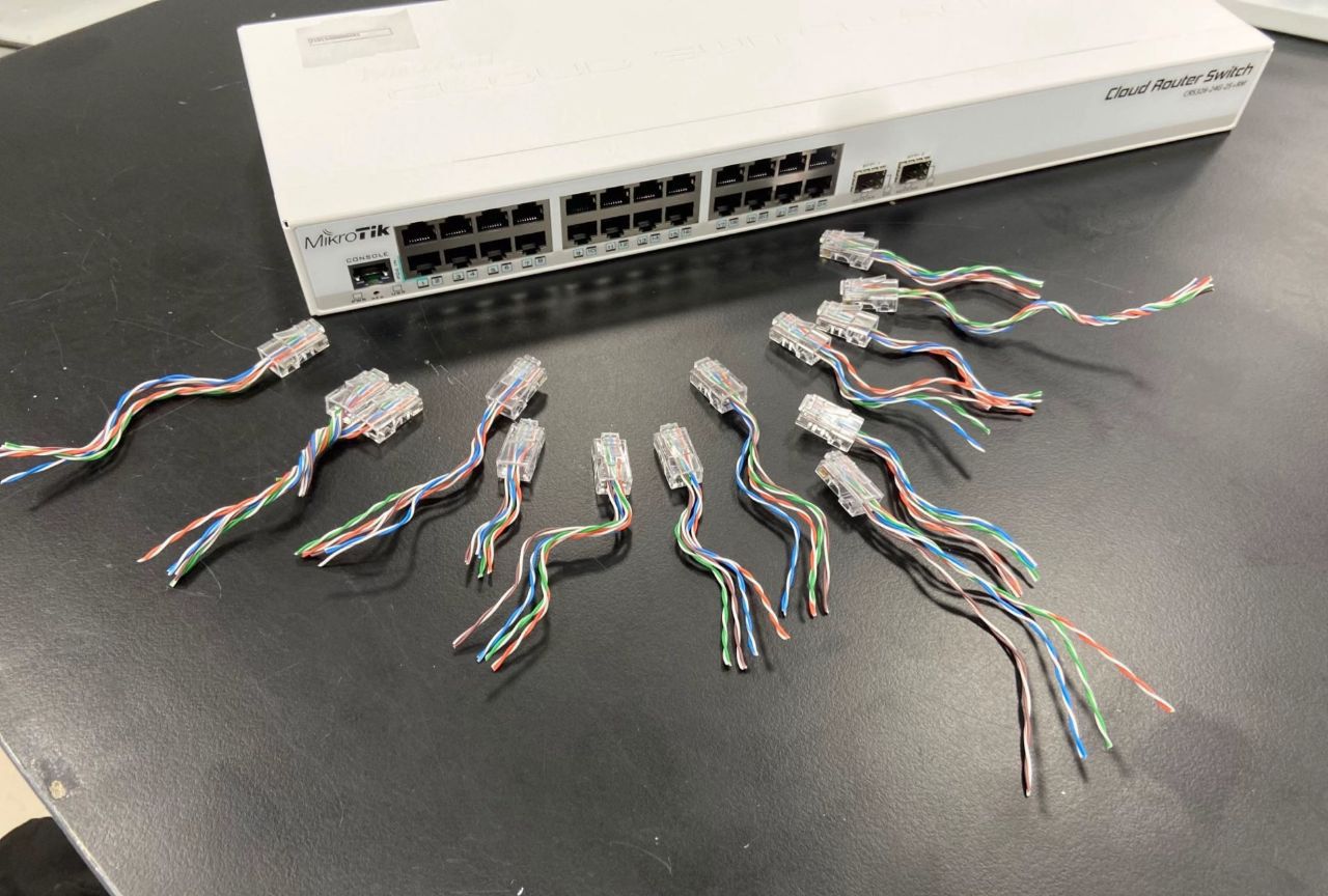 Коммутатор и множество кабелей витых пар на столе