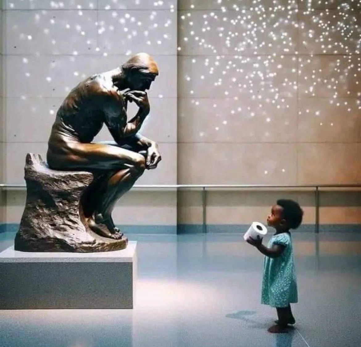 Маленькая девочка держит книгу перед статуей Думающего человека в музее.