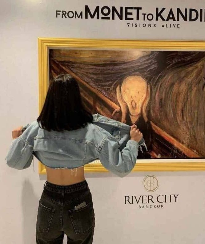 FROM MONET TO KANDINSKY VISIONS ALIVE RIVER CITY BANGKOK. Девушка стоит спиной к картине, похожей на «Крик» Мунка, и поднимает свою куртку, обнажая поясницу.