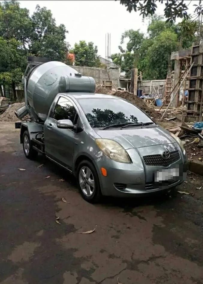 Серый авто с цементовозом на строительной площадке