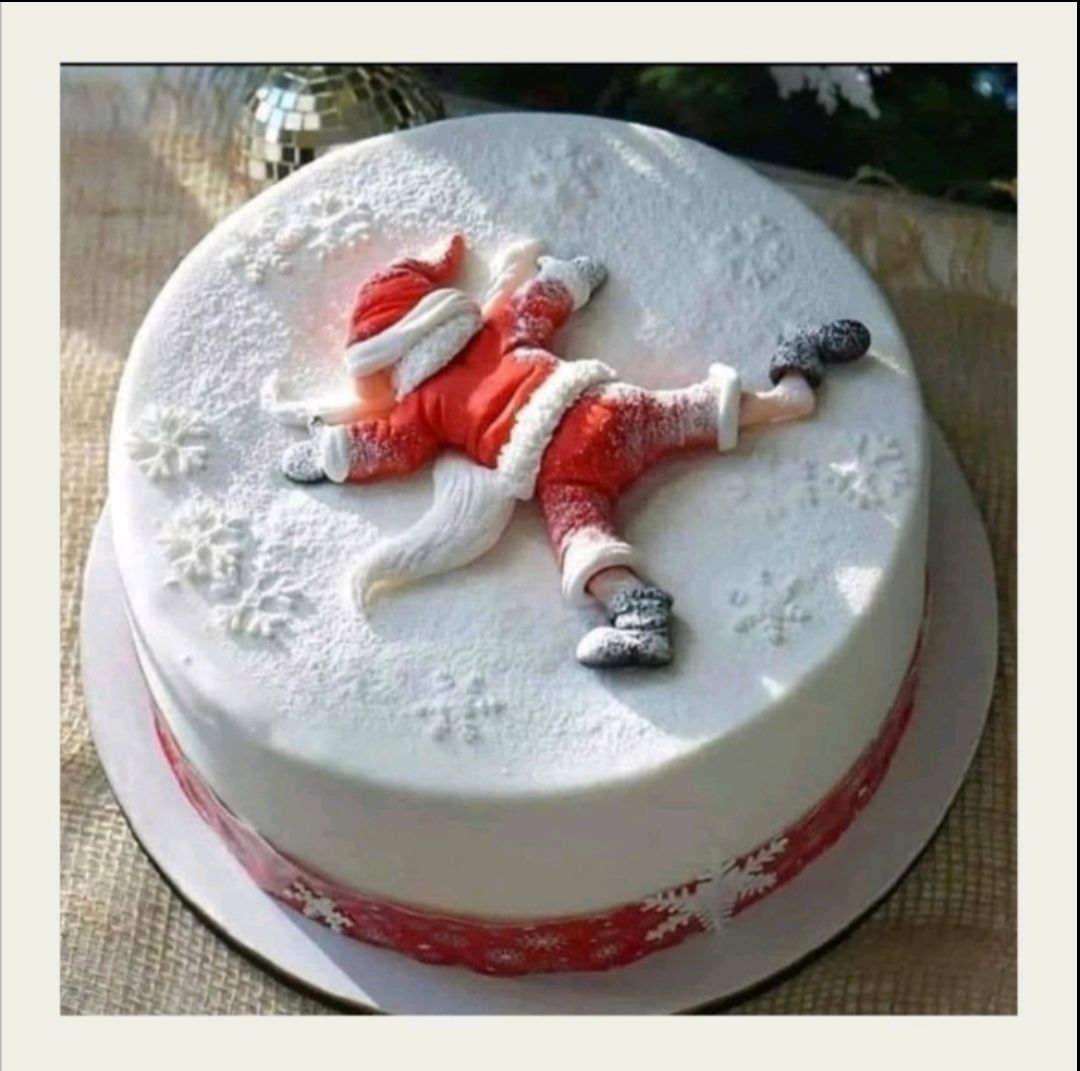 Новогодний торт с фигуркой Санта-Клауса на белой глазури и снежинками.