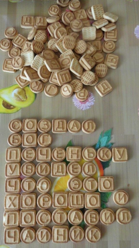 Горы деревянных буквеных плиток на поверхности стола, часть из них сложена в строки.