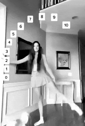 девушка танцует рядом с подвешенными цифрами от 0 до 10 в черно-белом кадре