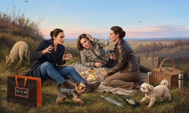 Трое девушек на пикнике в поле с собаками и корзинкой возле уютной трапезы