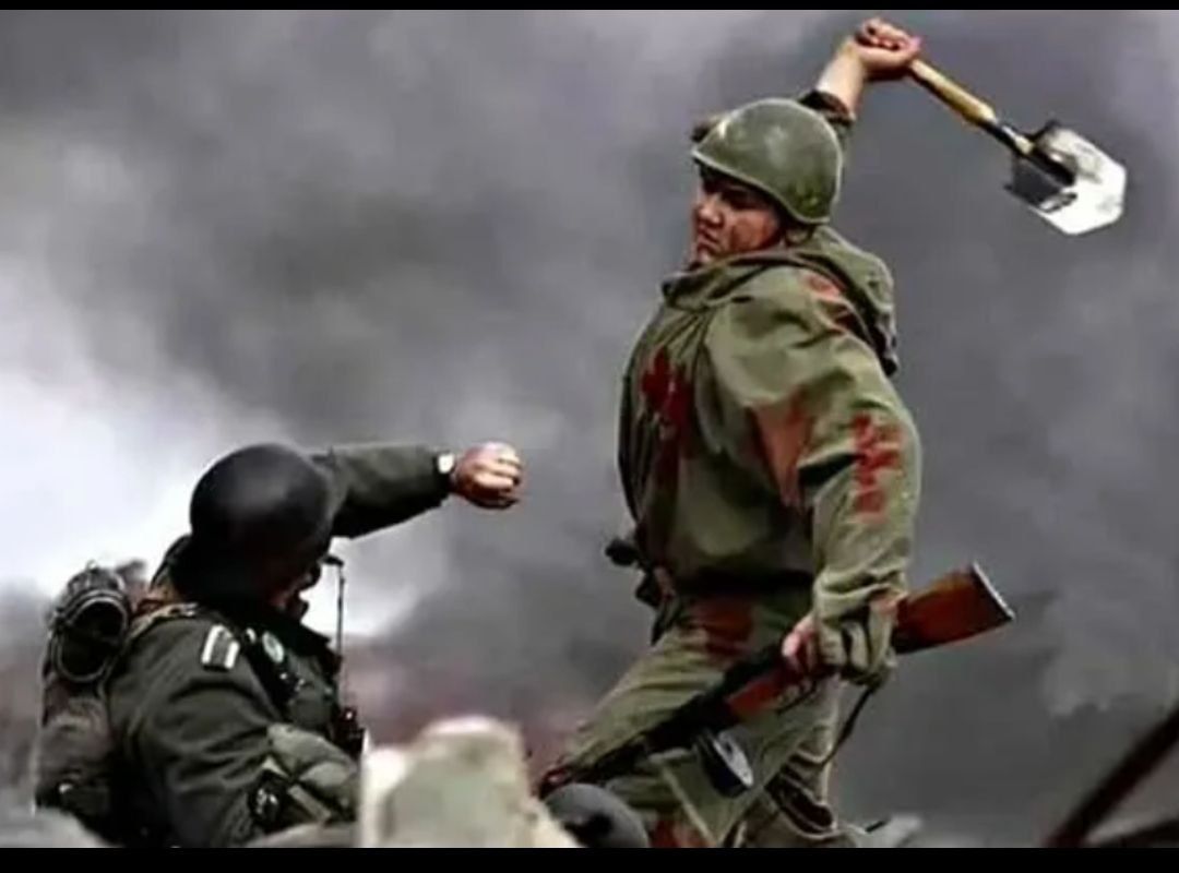 Сцена боя: солдат поднимает топор над противником на фоне дыма и огня.