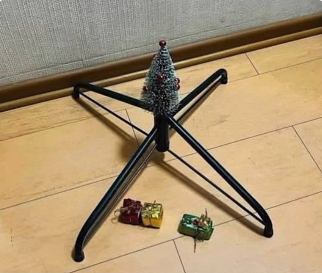 Новогодняя ёлочка на штативе с подарками вокруг.