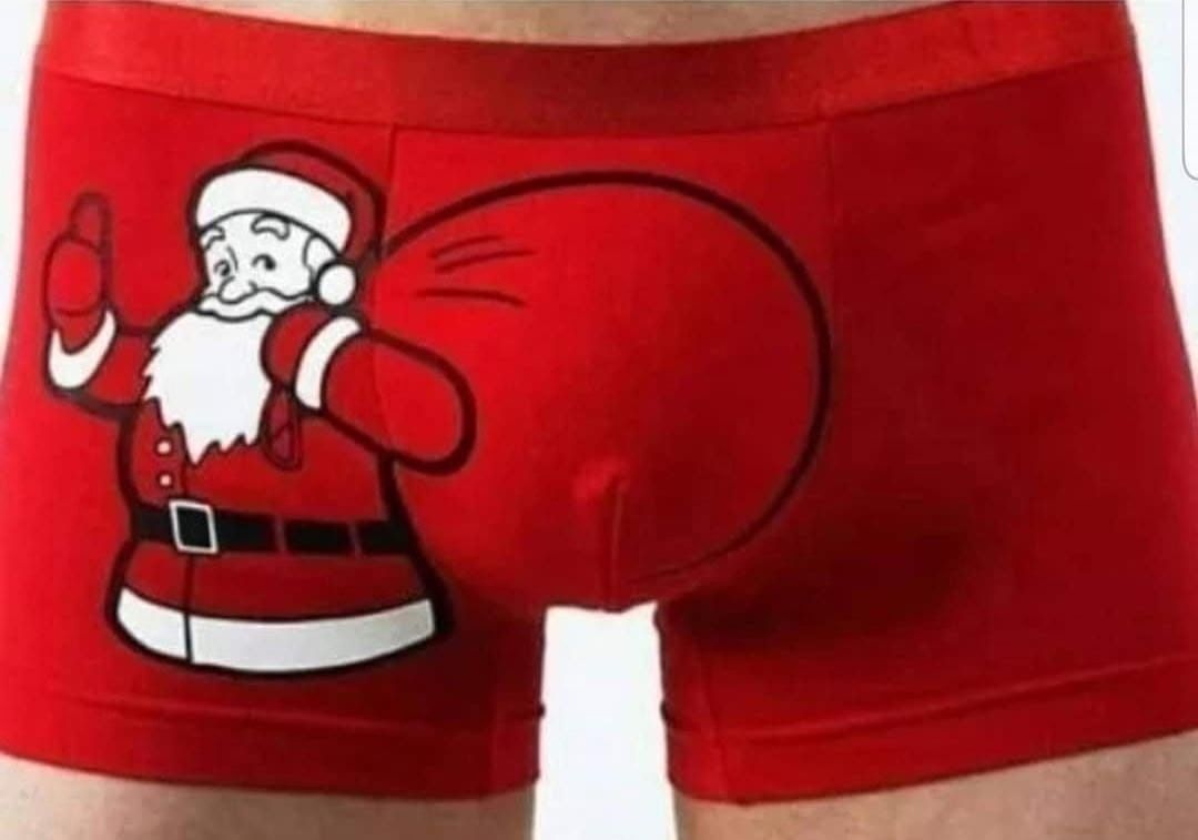 Человек в красных мужских трусах с изображением Санта-К Claus на передней части