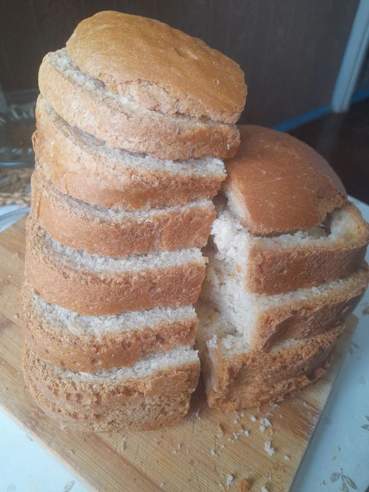 Домашний хлеб, нарезанный многими ломтиками, на разделочной доске