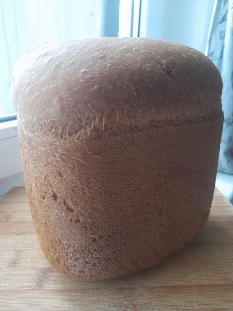 Квадратный хлеб, поставленный на деревянную доску возле окна