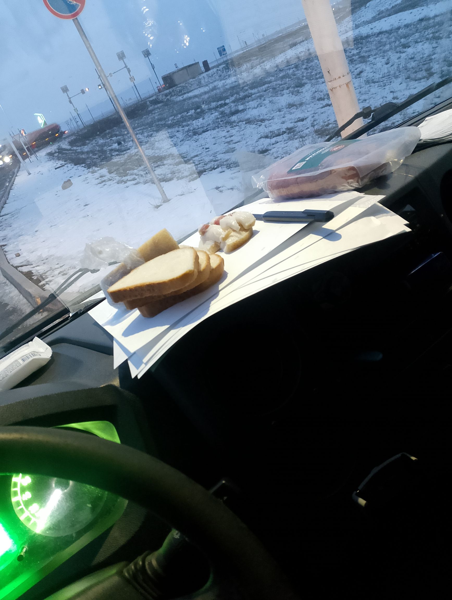 Закуска на панели приборов в автомобиле зимой у окна на улице