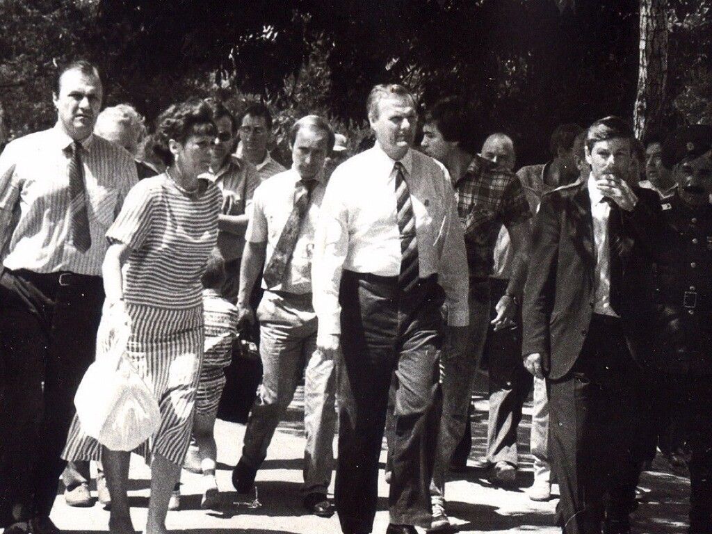 Черно-белое фото группы людей, идущих вместе по улице