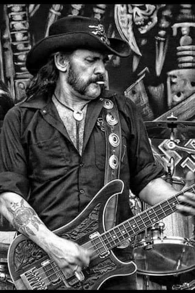 Музыкант играет на бас-гитаре на сцене в черно-белом кадре.