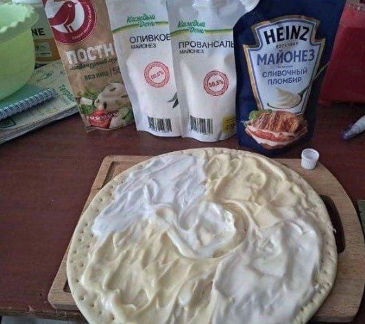 HEINZ Майонез, Провансаль, Оливковый. на столе пакетики с соусами; круглый пирог/пицца с белым кремом сверху.