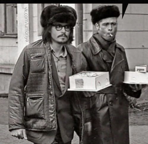 Два мужчины в винтажной одежде с коробками еды на улице