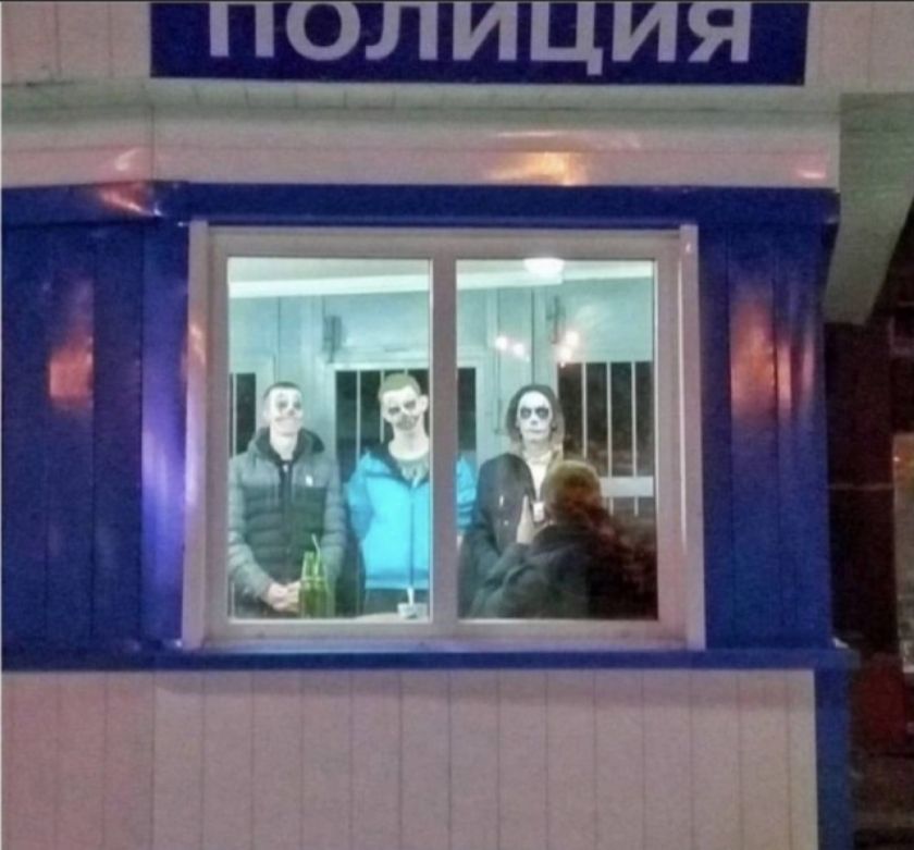 ПОЛИЦИЯ (перевернуто). Три человека с гримом в виде черепов стоят у окна, перед ними человек со спины. На столе видны бутылки.