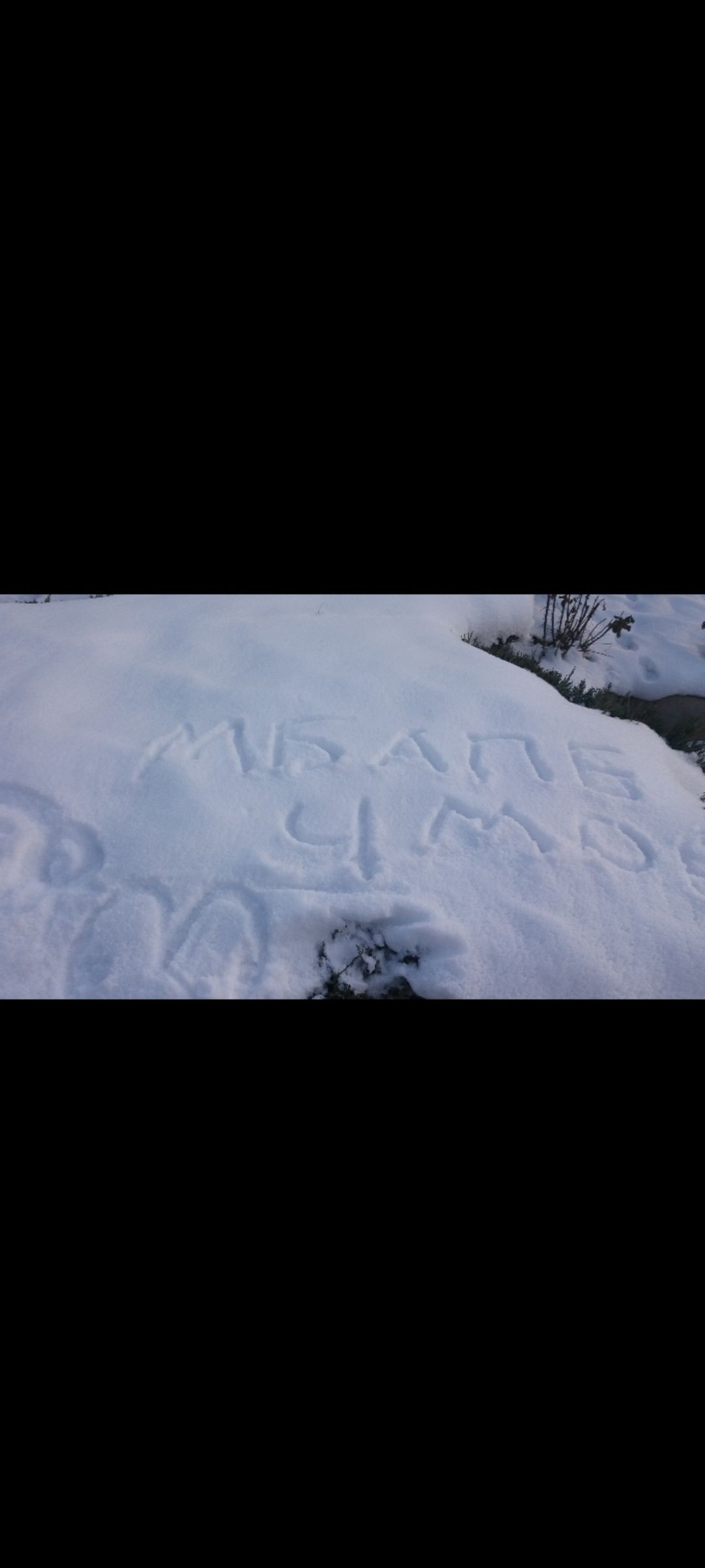 На снегу вырезаны буквы кириллицей; часть надписи читается как «МИР», остальное неразборчиво.