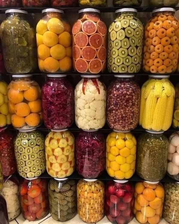 много jars с засолками и консервами на полке