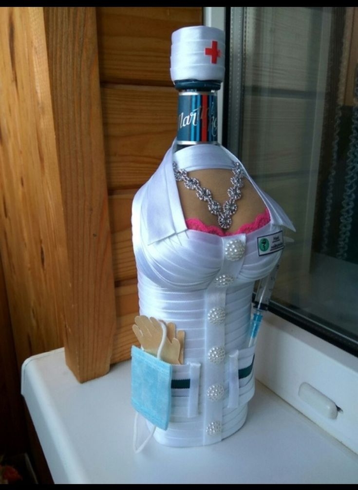 Бутылка воды одета в белый корсет с аксессуарами и медицинскими принадлежностями