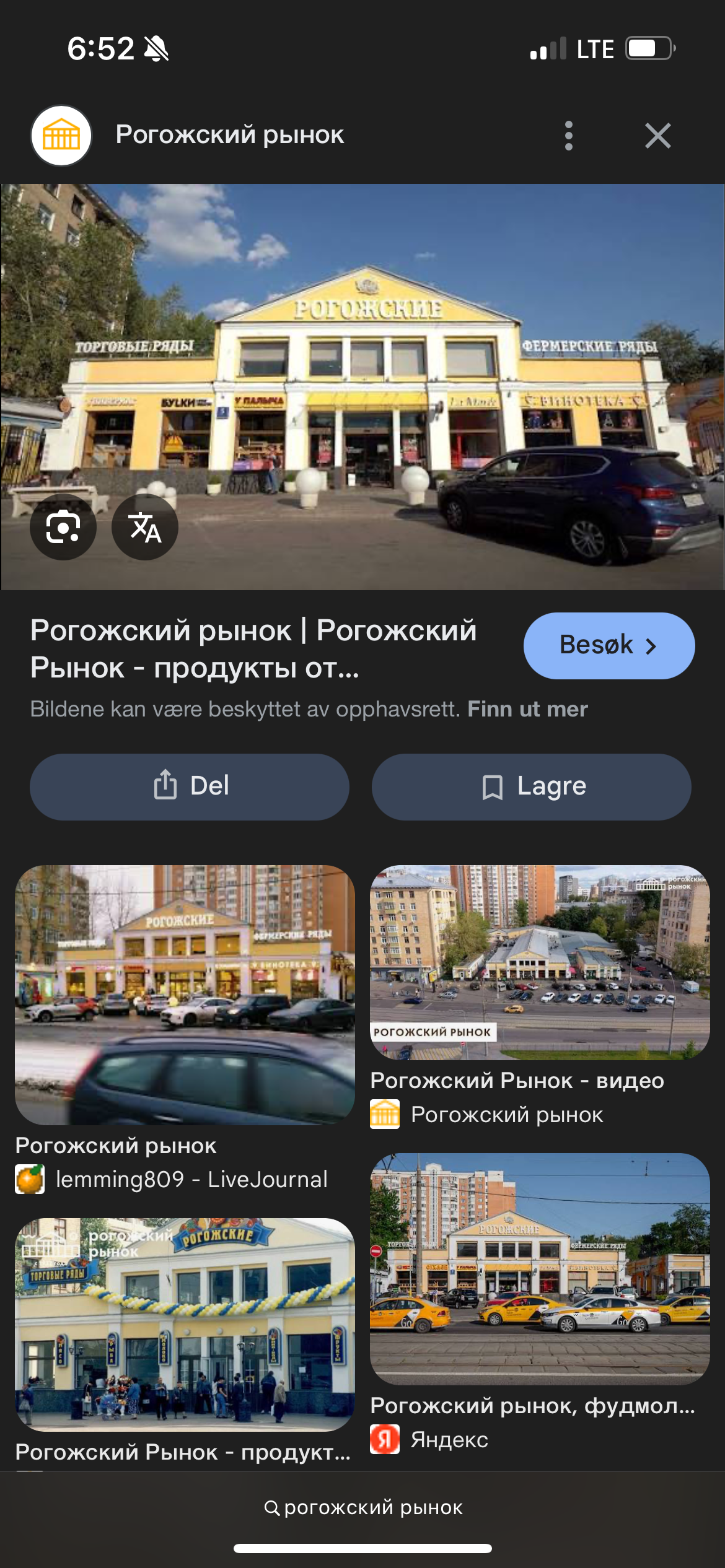 Рогожский рынок. Вид фасада рынка с надписями: РОГОЖСКИЕ, фермерские ряды, торговые ряды, продукты. На переднем плане автомобиль и вход в здание.
