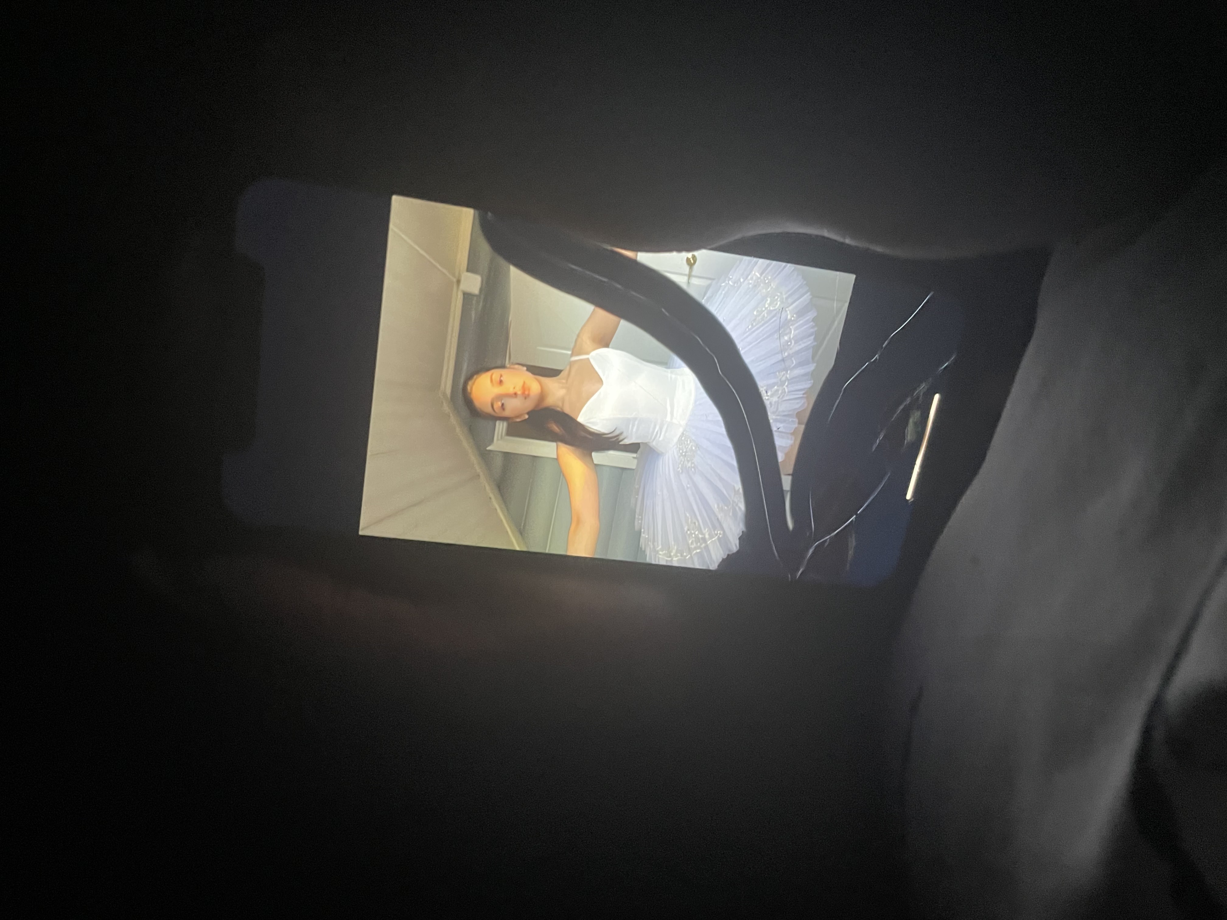 Человек лежит на кровати, снято через телефон в темной комнате