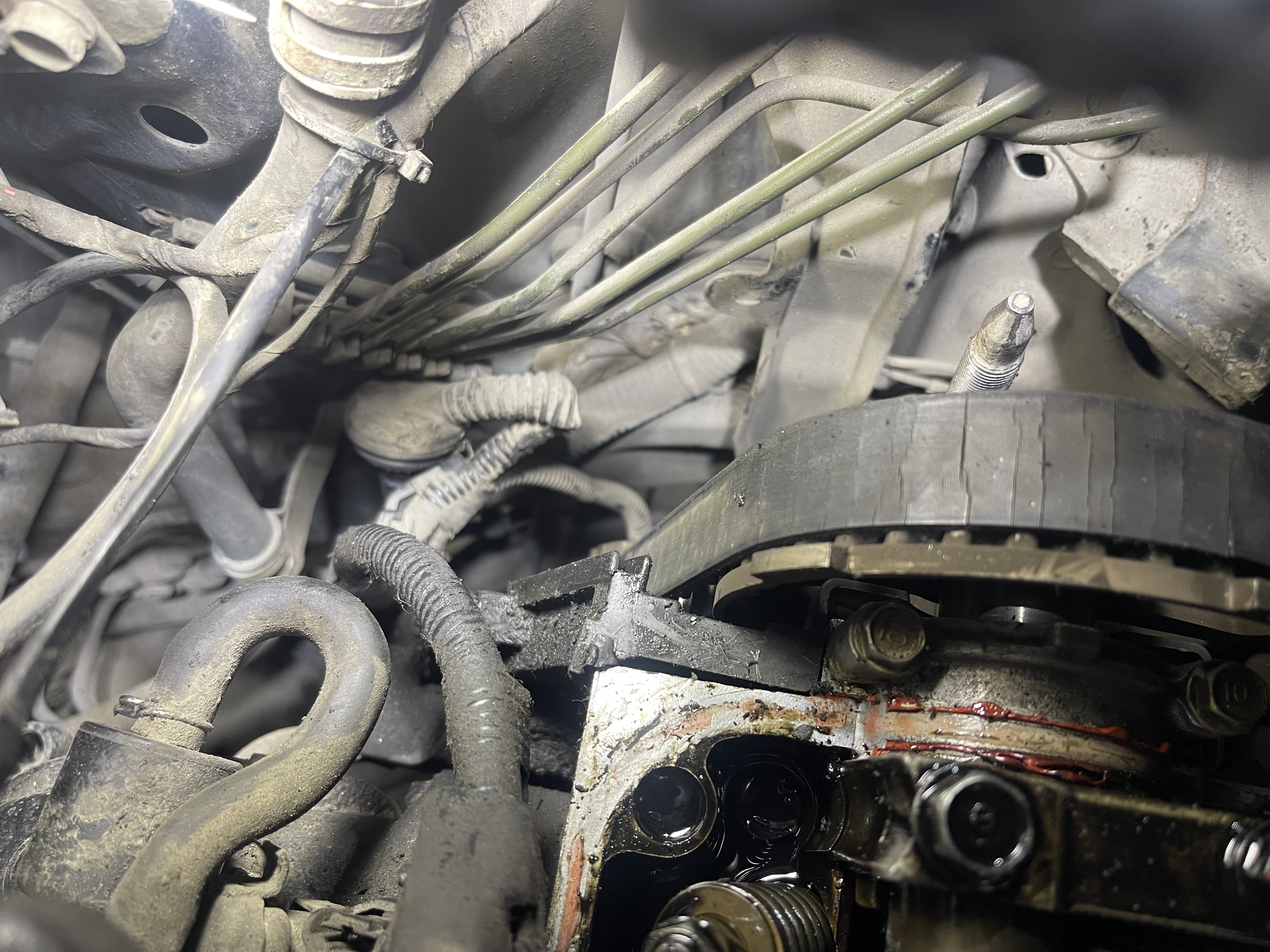 Загрязнённый двигатель, видны детали и масляная утечка