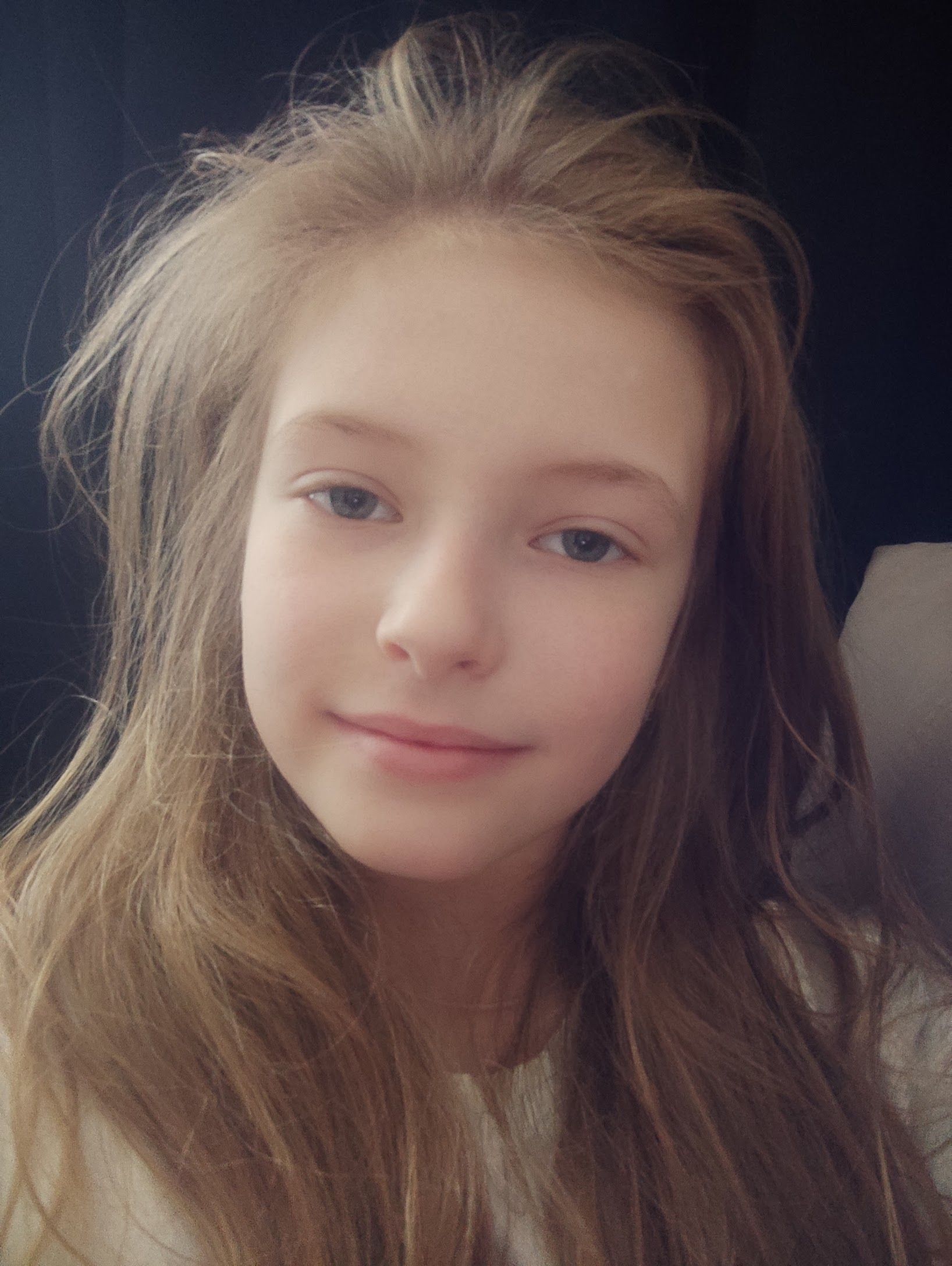 Селфи молодой девушки с нейтральным выражением лица.