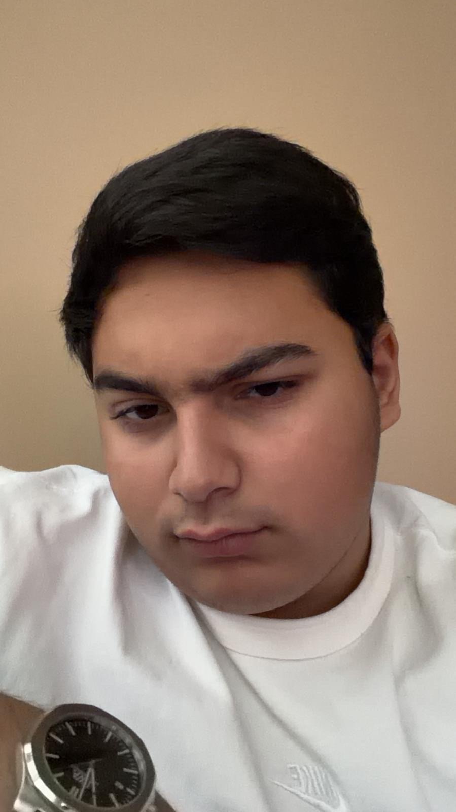 Мужчина в белой футболке смотрит вниз, снимает селфи