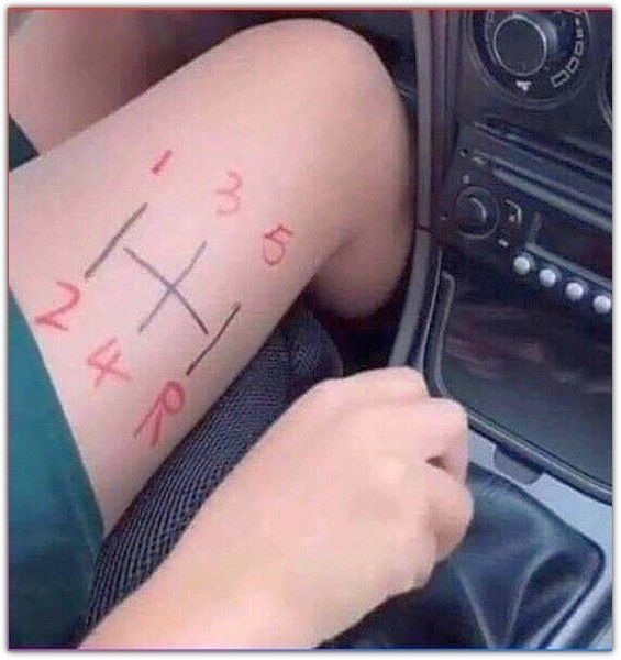 Человек рисует крестики-нолики на голени рядом с рычагами автомобиля