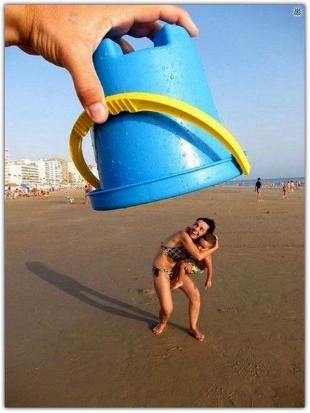Человек держит над пляжем огромное синее ведро, готовое упасть на девушку.