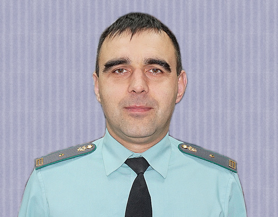 Мужчина в форменной голубой рубашке с эполетами и галстуком