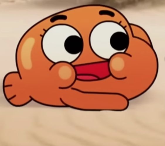 Мультяшный симпатичный оранжевый персонаж с большими глазами лежит на песке